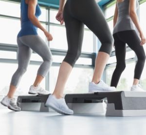 Three women doing aerobics in gym